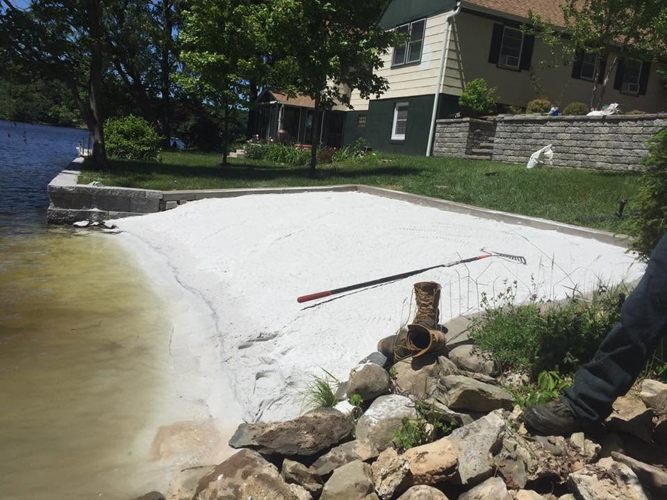 Lakeside stone beach install with block retaining wall
